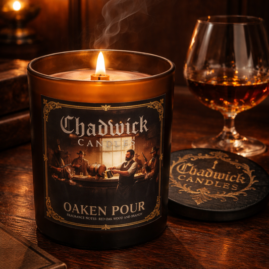 Chadwick Candles Oaken Pour candle on a wooden surface with a glass of whiskey and coaster.