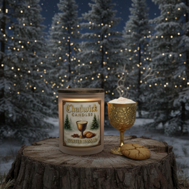 Candle and goblet on a log with snowy trees in the background